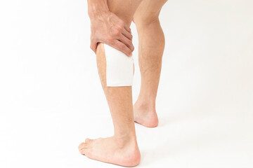 湿布を貼った男性の脚　白バック
