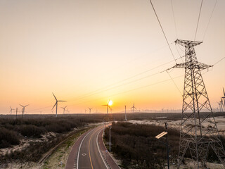 highway through wind power station and pylon