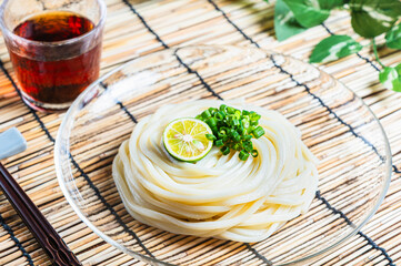 すだちと青ねぎを添えたシンプルな冷やしうどんの夏向け和食
