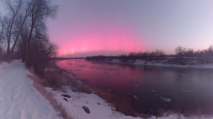 Pink atmospheric phenomenon over a winter river.