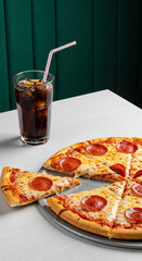 A mouthwatering pepperoni pizza, with a refreshing cola drink, on a white table.