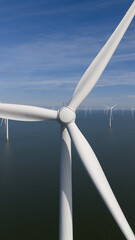 Offshore wind turbine fixed foundation, rotor, blades. Aerial drone video. Clean energy, renewable resource, wind power, wind farm.