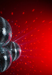 Disco balls with a vibrant red background create a fun party atmosphere.