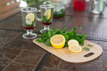 Ingredients for making a mojito at home. Lemon, mint, two glasses with syrup. summer. a refreshing...