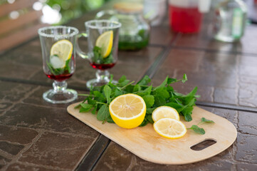 Ingredients for making a mojito at home. Lemon, mint, two glasses with syrup. summer. a refreshing...