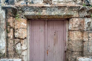 Puerta de madera pintada de rosa de un edificio histórico abandonado. 
