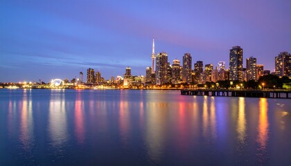 Fototapeta premium A city skyline at twilight, glowing lights from skyscrapers, reflected in calm water, captured with pristine focus