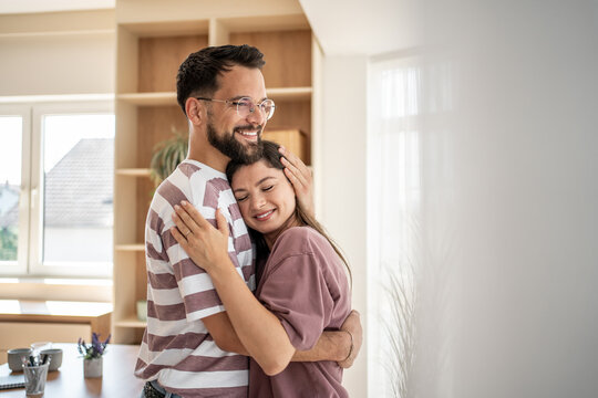 Happy couple embracing tenderly in their new home