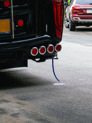 Air conditioning system drain pipe of bus drains wastewater onto road. Water droplets overflowing...
