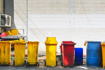 Lot of colorful trash cans on street. Wheelie bins in row segregated for recycling rubbish....