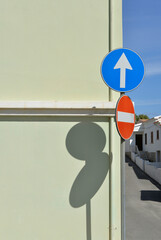 road signs with shadows on a building wall