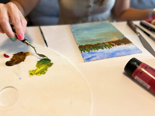 A close-up of a female painter demonstrating her craftsmanship as she works on a canvas with...