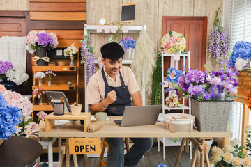 Small business, florist shop owner, flower man lifestyle managing phone call order from customer while tying ribbon, Asian florist entrepreneur multitasks at shop, male using smartphone technology