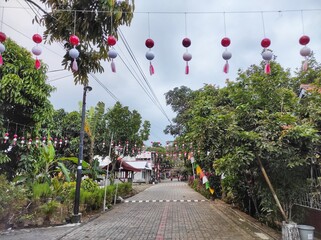 Celebrate 17agustus 1945  tradition with vibrant red and white decorations lining a festive village...
