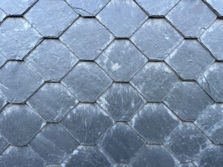 Close-up of gray slate tiles arranged in a diamond pattern. Natural stone texture, ideal for...