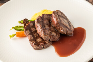 Juicy grilled filet medallions served with seasonal vegetables and sauce