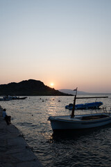 Fototapeta premium Sunset with boats and an island by the sea