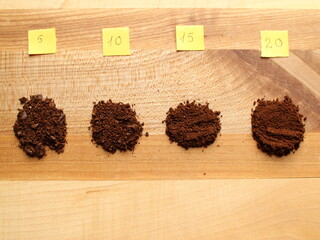 Coffee beans grinded at 5 second interval on a wooden background