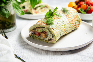 Appetizing zucchini roll with tomatoes and garlic on a light background