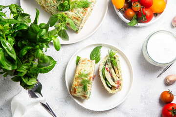 Appetizing zucchini roll with tomatoes and garlic on a light background
