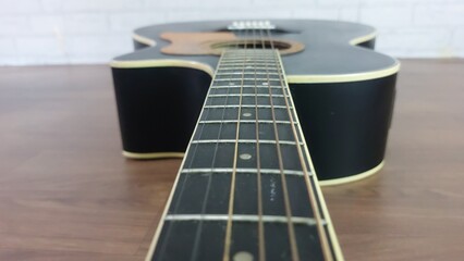 Obraz premium an elegant black acoustic guitar made of rosewood, with six steel strings that produce a melodious sound.