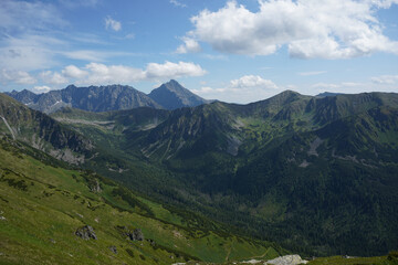 Fototapeta premium Mountain panorama in summer under blue sky with white clouds