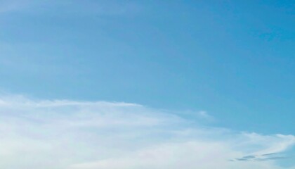 A clear blue sky with wispy clouds