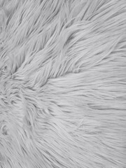 Background of light gray shaggy faux fur fabric. Shaggy faux fur fabric made of synthetic fibers...