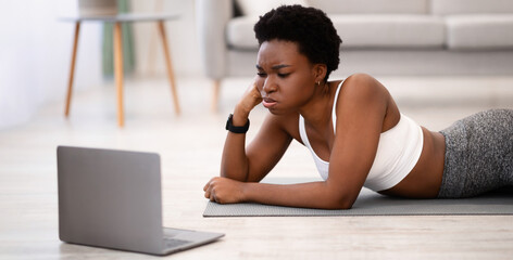 Exhausting Training. African Woman Exercising At Laptop Tired After Online Workout Watching Fitness...