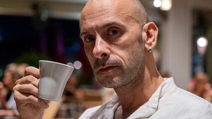 An attractive middle-aged man enjoying his coffee at a café during vacation