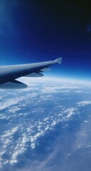Obraz premium Airplane wing extending over a vast expanse of clouds and sky