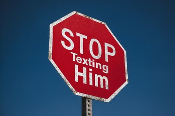 Obraz premium Red stop sign reading STOP Texting Him against blue sky
