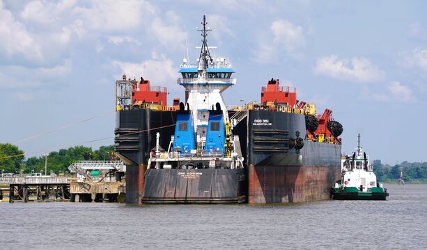 Delaware City, Delaware, U.S - August 2, 2025 - A barge and tugboat, working in tandem, illustrate the collaborative nature of maritime transport.