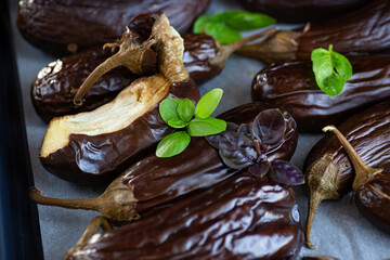 baked eggplants with basil lie on a baking sheet