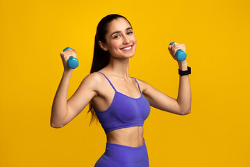 Fitness And Sport Concept. Portrait Of Smiling Young Woman Exercising With Two Dumbbells Posing...