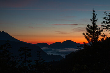 Magical sunrise over Stubenalm at Watzmann – gentle mist drifts through the alpine meadows,...