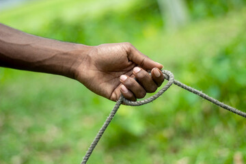 A young man holds a cow rope and the background is blurred