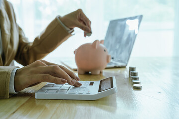 A hand places coins into a growing stack, symbolizing saving, investment, financial planning,...