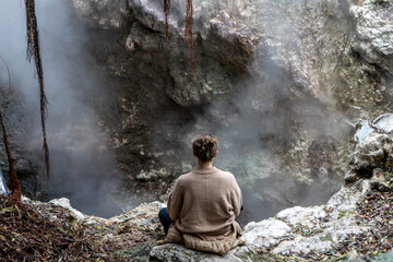 Woman meditating peacefully by geothermal hot springs at Furnas, S&atilde;o Miguel Island, Azores. Serenity, nature, wellness, and volcanic landscape in harmony.
