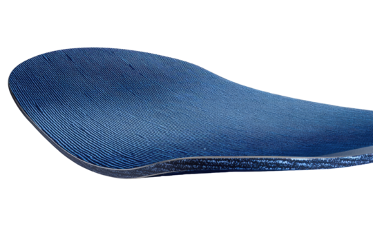 Close-up of a dark-blue, curved, layered material.  A smooth, textured surface with a subtle, layered design