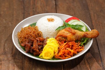 Nasi uduk is a dish made from diaroned white rice steamed with coconut milk, and seasoned with...