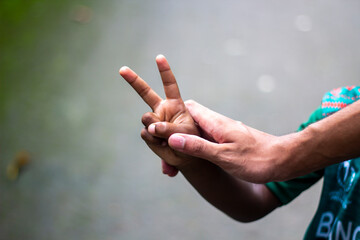 A man pointing two fingers of his hand forward and green background