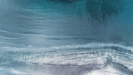 Turquoise waters gently lap against striking sandy shores in the Faroe Islands. Tjornuvik village,...