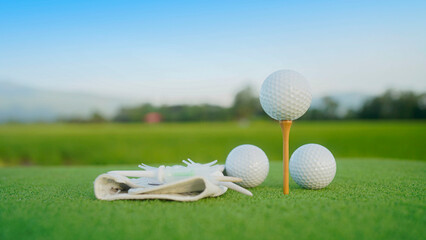 Close-up golf ball on tee with blur green bokeh background.