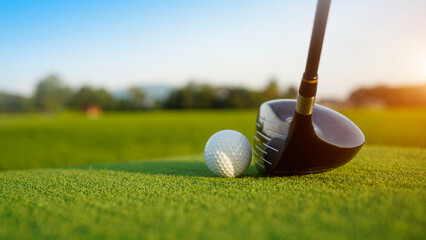 Golf clubs and balls on a green lawn in a beautiful golf course with morning sunshine.