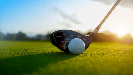 Golf clubs and balls on a green lawn in a beautiful golf course with morning sunshine.