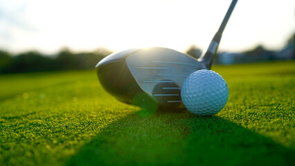 Golf clubs and balls on a green lawn in a beautiful golf course with morning sunshine.
