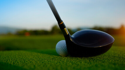 Golf clubs and balls on a green lawn in a beautiful golf course with morning sunshine.