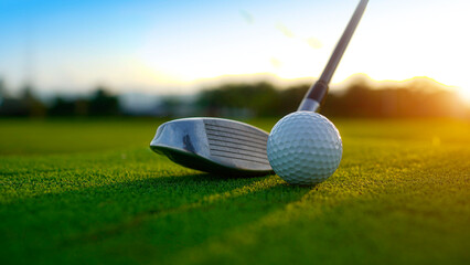 Golf clubs and balls on a green lawn in a beautiful golf course with morning sunshine.