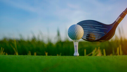 Golf clubs and balls on a green lawn in a beautiful golf course with morning sunshine.